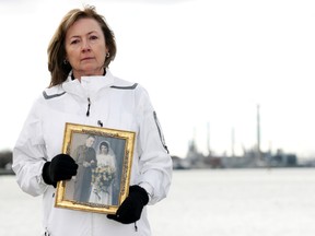 Trish Daubs holds a photo of her parents, standing with the Imperial Oil refinery where her father worked in the background. Her mother and father, it's suspected, died from mesothelioma due to asbestos exposure. Daubs will be present at the Canadian Cancer Society's annual Daffodil Breakfast fundraiser April 3. SUBMITTED FROM THE CANADIAN CANCER SOCIETY/ FOR THE OBSERVER/ QMI AGENCY