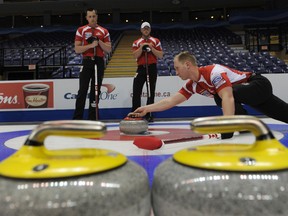 Canada skip Brad Jacobs delivers his stone as his front end of brother E.J. and Ryan Harnden look at his delivery during practice Friday prior to the start of the world championship.
Michael Burns/CCA