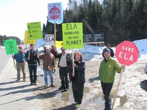 ELA supporters carry signs protesting the closure of the Experimental Lakes Area during a demonstration at the Highway 17 entrance to the fresh water research facility, Saturday, March 30.