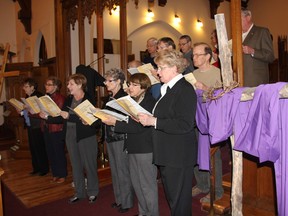 SEAN CHASE    The Holy Trinity Anglican Church choir sings a hymn as part of the Way of the Cross observed Friday in Pembroke. The two-hour procession retraces the 13 stages of Jesus’ final hours.