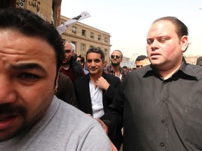 Bodyguards surround Bassem Youssef (C), the country’s best-known satirist, as he arrives at the high court to appear at the prosecutor’s office in Cairo March 31, 2013.  REUTERS/Mohamed Abd El Ghany