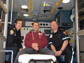 Bill Fox (centre) sits with paramedics Brian Truchan (left) and Jon Schwab inside an ambulance outside the Queen Elizabeth II Hospital (10409-98 Street). Against the odds, the specially-trained paramedics saved Fox’s life after he suffered a severe heart attack in Fairview in December 2012. (Elizabeth McSheffrey/Daily Herald-Tribune)