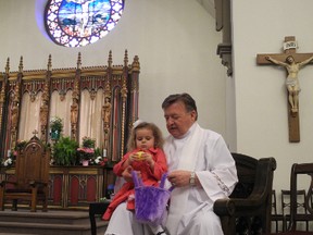 Arabella MacLachlan, 2, visits with Rev. Hamish Currie following an Easter egg hunt at Precious Blood Cathedral in 2013. Currie is pastor of Sault Ste. Marie's oldest Catholic church.