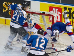 Dylan Wruck, right, crashes into the net as Brock Montgomery, left, and Luke Philp try in vain to score on  Laurent Brossoit during the third period at Rexall Place on Friday. The Oil Kings won 4-1, eliminating the Ice from the WHL playoffs.
Amber Bracken/Edmonton Sun