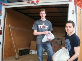 Timmins High students Lucas Charette, left, and Ryley Hardisty help to load a cube van with donated food which students collected earlier in the day. About 250 students were involved in the school’s 14th-annual Food for Friends Food Drive.