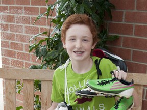 Zach Lollar, a Grade 7 Challenge student at Loughborough Public School, shows off some of the soccer gear he collected for the Kicks 4 Kids program. “I just want people to be active and have fun like me,” Lollar said with a grin. (Laura Boudreau For The Whig-Standard)