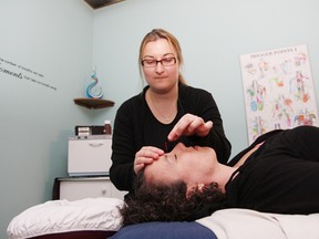 Sylvia Frappier, a registered massage therapy practitioner of acupuncture, demonstrates her skills on her colleague, Kim Barr, at All About Massage and Laser Services on Durham Street. An open house was held at the business to show off the facilities and services available to clients, including new
acupuncture services.
John Lappa/The Sudbury Star