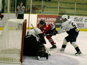 Evan Warmington tries to get the puck in past Saints’ goalie Kenny Cameron while Brandon Hickey blocks him. The Saints beat the Wolverines 2-1 in triple overtime on Thursday, March 28 in Spruce Grove at the Grant Fuhr Arena.
Gord Montgomery | QMI Agency