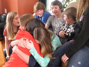 Friends embrace in Ingleside after they believed that they were talking to Lena Dolan from her home in Japan during March Break.