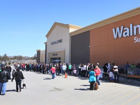 People line up outside Wal-Mart in Port Elgin to purchase burgers and pop during a fundraiser Saturday for the victims of a house fire in Southampton.