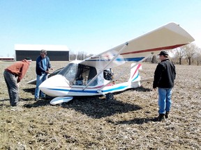 Three unidentified men inspect an ultralight aircraft after it made an emergency landing on farmland near Dresden, Ontario on Saturday March 30, 2013. No one was injured in the incident. (Contributed photo by Derek Hueni)