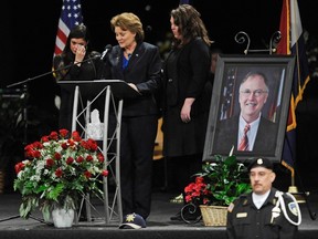 Lisa Clements, the widow of chief executive of the Colorado Department of Corrections, Tom Clements, is supported by her daughters Sara (L) and Rachel as she speaks at his memorial at New Life Church in Colorado Springs, Colorado March 25, 2013. (REUTERS/Jerilee Bennett/The Gazette/Pool)
