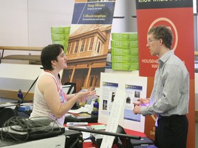 Jacqui Cottrell talks to Chris Gowan, intern with the city's environmental services department during Tuesday's Energy Fair at Canadore College. More than 20 exhibitors were onsite showcasing eco-friendly products like electric and hybrid vehicles, free energy conservation giveaways including blue spruce saplings.