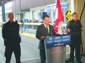 Flanked by two Canadian Border Service agents at the Thousand Islands Bridge crossing, Leeds-Grenville MP Gord Brown announces $60 million of improvements to the border crossing, including five new lanes.