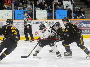 Quinte West Major Bantam Hawks' Matt Miller tries to fend off a pair of Brampton 45's checkers during Saturday's 4-2 loss at the Community Gardens as Brampton claimed the OMHA championship.