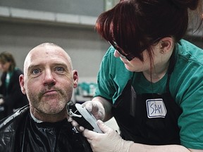 Calvin, left, gets a shave from Sam during Homeless Connect at the Shaw Conference Centre in Edmonton in April 2012. File Photo/QMI Agency