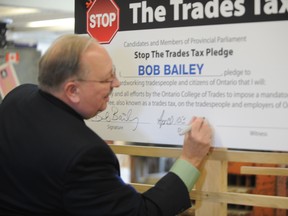 Sarnia-Lambton MPP Bob Bailey takes the 'Stop the Trades Tax' pledge Wednesday. Bailey said consumers will feel the hit of increased annual trades taxes on everything from haircuts to car repairs. BARBARA SIMPSON / THE OBSERVER / QMI AGENCY