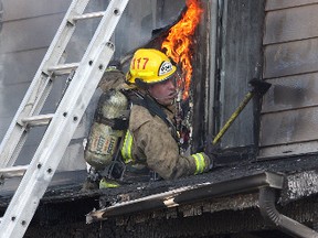 Kingston Fire and Rescue firefighters including firefighter Tyler Niellissen  battle a fire in two townhouse units at 347 Yonge Street Wednesday afternoon.
Ian MacAlpine The Whig-Standard