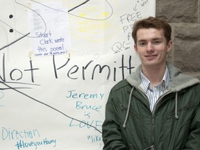 Queen’s Students for Liberty spokesman Tyler Lively stands in front of the group's "free speech wall" that was taken down by Queen's University officials on Tuesday evening.