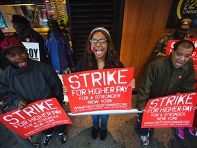 Demonstrators protesting low wages and the lack of union representation in the fast food industry chant and hold signs outside of a McDonald's restaurant near Times Square in New York, April 4, 2013.  REUTERS/Lucas Jackson
