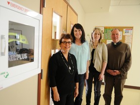 Lola Wright, left, and Dawn Marie Crouse, second-right, share a new automated external defibrillator with Laura LaValley, executive director of the Regional EMS Foundation and Father Remi Hebert Thursday. Wright and Crouse hosted a motivational speaker in 2012, which resulted in a $4,000 profit, which they used to purchase two new AEDs for the Swan City. ADAM JACKSON/DAILY HERALD-TRIBUNE