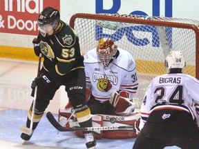 Attack goaltender Jordan Binnington makes a save despite being screened by Bo Harvat of the London Knights during an OHL regular-season game in Owen Sound late in November. Looking on is Attack defenceman Chris Bigras.