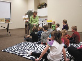 Devon Public Library program coordinator Holly Gilmour reads to a group of kids during the library’s Magic Time early literacy class on Wednesday, Apr. 4.