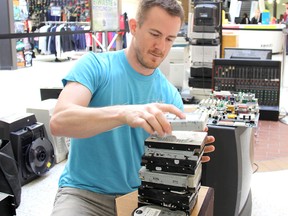 Installation artist Mark Reinhart puts some finishing touches on his e-waste display inside the Downtown Chatham Centre Friday to promote a waste recycling event to raise money for Habitat for Humanity Chatham-Kent later this month. VICKI GOUGH/ THE CHATHAM DAILY NEWS/ QMI AGENCY