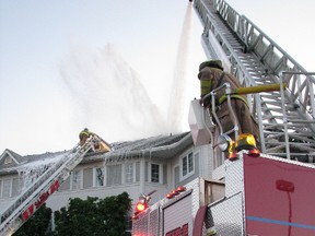Residents of 36 condominiums at Mariner and Venetian Village in Point Edward, Ont., near Sarnia, waited for word Wednesday, May 23, 2012, they could return home after fire damaged about a dozen units Tuesday night. Here, firefighters douse the roof of the still smouldering structure on Tuesday. (CATHY DOBSON, The Observer)