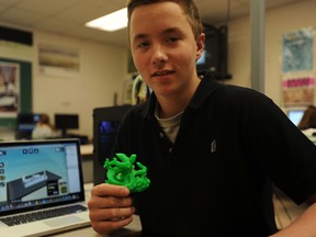 St. Chris student Ryall Willemsen shows off a dragon created in his technology class Friday. Students are experimenting with a new three-dimensional printer, allowing them to create plastic prototypes based on their CAD designs. (BARBARA SIMPSON, The Observer)