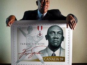 Fergie Jenkins poses in 2010 with the art for a stamp created in his honour. Today he is a retired after a Hall of Fame career in pro baseball, and a Canadian hero. In 1966 things were much different.
