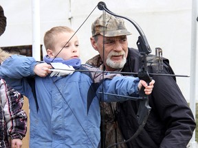 Patrick Myers, 7, of Chatham, gets some pointers on archery from Jon Wood, of the Kingsville Wild Goose Archery Club, Saturday, during the Big Buck & Bull Day 2013 held in Tilbury.