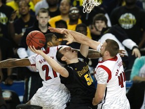 Wichita State forward Jake White (50) is stopped in his tracks by Stephan Van Treese (right) and Chane Behanan of the Louisville Cardinals during last night’s NCAA semifinal in Atlanta. The Cards turned up the defence to win by four. (REUTERS)