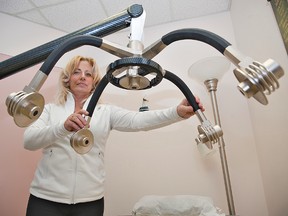 Calinda Simon demonstrates the laser weight loss equipment in a treatment room at Zerona Canada which held its grand opening Saturday at 525 Park Road North in Brantford. (BRIAN THOMPSON The Expositor)