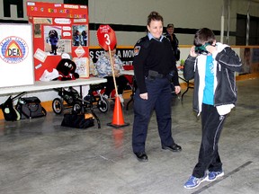 Special Const.Brenda Koldyk, of the Chatham-Kent Police Service watches 11-year-old Niall Hetherington of Ecole Ste-Catherine in Pain Court, Ontario try to walk a straight line while wearing a pair of goggles simulating  impairment during the Racing Against Drugs workshop on Monday April 8, 2013.   
(VICKI GOUGH/ THE CHATHAM DAILY NEWS/ QMI AGENCY)