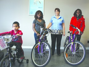 THERESA SERAPHIM/COLD LAKE SUN
(From left) Jariah Keesaynew, Thandie Ntim and Tianna Ntim pose with the bikes they were given by Donna Gamblin (centre). Gamblin, manager of Cash Canada Cold Lake, decided to give away bikes each month out of her own pocket, as a way of giving back to the community by helping some of the children.