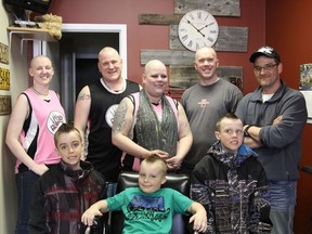 Eight people shaved their heads to raise money for cancer this past weekend. (Front l-r) Jacob Blais, 7, Mase Noland, 5, Noah Blais, 9, (back l-r) Norna Hugasdóttir, Ray Froud, Christine Froud, Scott Ulvstal and Mitch Boucher (missing from photo)all had their heads shaved by Don Dupuis (far right) at Don's Barber Shop.