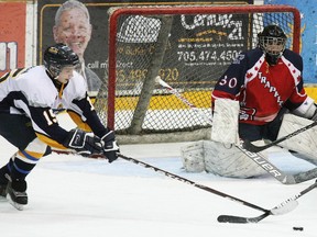 North Bay Jr. Trappers goalie Greg Dodds and Beau Orser (4) watch as Connor Gilmartin (11) dives to clear a puck from Kirkland Lake Gold Miner Steven Babin (15) in the final minute of their semi-final playoff game, Thursday. North Bay is moving on to the NOJHL championship final to play the Soo Thunderbirds after defeating Kirkland Lake 4-2, winning a tough, tight series four games to one.