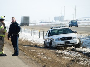 Near Carstairs, Alta. �  A sheriff and a Carstairs fire fighter stand near an immobilized Alberta Sheriff patrol cruiser that sits mangled in the median on Highway 2 northbound, about two kilometres south of Highway 581 around 5:30 p.m. Monday, April, 8, 2013. The Sheriff was allegedly run off the road when a suspected stolen truck hit him. The suspects fled the scene, later and allegedly stole another truck, but were captured shortly after 6:30 p.m.
JAMES EMERY/AIRDRIE ECHO/QMI AGENCY