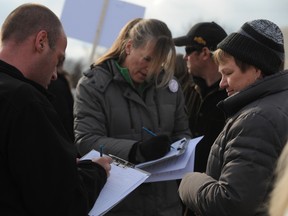 Community members fill out objection letters outside Suncor's public meeting in Camlachie last week. Representatives of area groups against the company's planned wind turbine project provided more than 700 signed objection letters and a petition with more than 2,700 signatures following a trio of public meetings. THE OBSERVER/QMI AGENCY