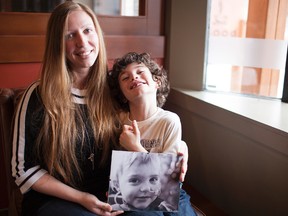 Amanda Carrington sits with her son Matthew, holding a picture of her other son Ryan, who passed away from a brain tumour last year. The Carringtons are keeping Ryan’s memory alive by hosting a fundraising event for the Kids Cancer Care Network, in hopes of raising awareness for childhood cancer in the Bow Valley community on  May 3, 2013. Glenn Kelly/ For the Leader