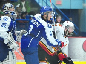 Sudbury Wolves Cory Genovese and Belleville Bulls Michael Curtis fight for position in front of Wolves goalie Frank Plazzese in this April 2013 file photo.