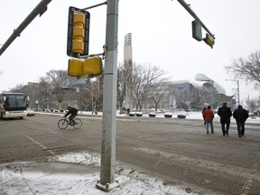 Edmontonians cross 100 Street next to Churchill Square as snow falls on April 15, 2013. Ian Kucerak/QMI Agency