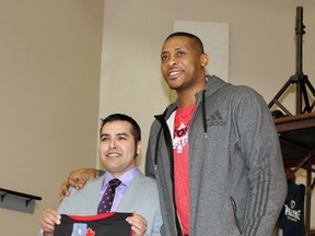 Former Toronto Raptors player Jamaal Magloire presents Missisauga First Nation Chief Reginald Niganobe with a jersey on Saturday. Bottom: Magloire spent some of his time signing autographs for the more than 100 people in attendance.