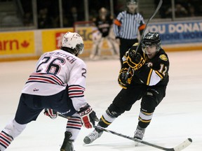 Sarnia Sting forward Charlie Sarault, right, chips the puck past Oshawa Generals defenceman Geoffrey Schemitsch earlier this season. Sarault was named the OHL's top overage player for 2012-13 on Wednesday. PAUL OWEN/THE OBSERVER/QMI AGENCY