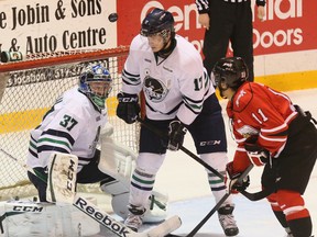 The puck rebounds over Plymouth Whalers goalie Matt Mahalak while Owen Sound Attacks Cameron Brace and Whalers Sebastian Vanderwiel wait out front of the net during second period OHL playoff action on Wednesday, April 10, 2013 at the Lumley Bayshore in Owen Sound.