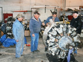 The Fairview Aircraft Restoration Society recently finalized a deal with the towns of Stephenville and St. Anthony in Newfoundland for a pair of engines to power the Canso, getting it much closer to being ready to lift off. Pictured, left to right, Don Wieben, John Campbell, Jim Allan were assembling a non-running Pratt and Whitney aircraft engine to send to Newfoundland in exchange for a running example and Doug Roy was there to check it out. (Chris Eakin QMI Agency)