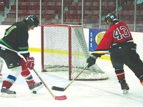 A member of the Whitefish Bay Old Timers, in red, tries to put the puck past the oppsing Whitedog Smoothies. Whitefish Bay won their first game of the North American First Nations hockey tournament 13-5 on Thursday, April 11. 
GRACE PROTOPAPAS/Daily Miner and News