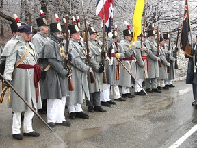Reenactors portraying members of the Canadian Fencibles and the Canadian Voltigeurs salute the marchers along Hwy. 2 between Gananoque and Kingston Friday on the final leg of a recreation of a February 1813 march by soldiers to reinforce the garrison at Kingston against a possible American invasion.
Michael Lea The Whig-Standard