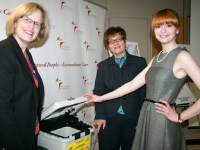 Taylor Purdy, right, a Blenheim native and University of Windsor student, is shown with Pat Campbell, Ontario Hospital Association CEO, far left, and Windsor West MPP and Minister of Children and Youth Services Teresa Piruzza with a reusable biomedical waste bin. CONTRIBUTED/ THE CHATHAM DAILY NEWS/ QMI AGENCY